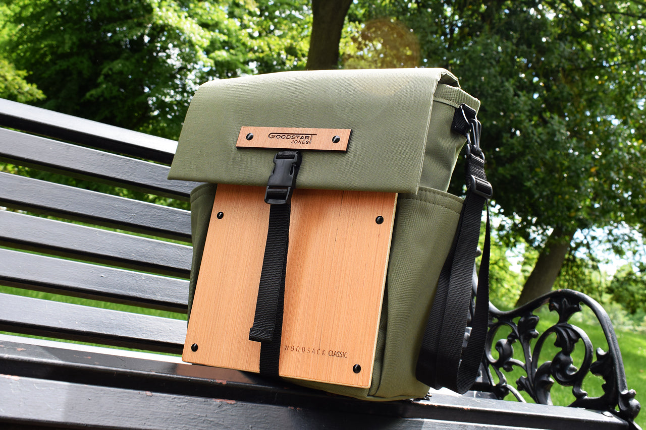 Woodsack olive backpack on park bench 